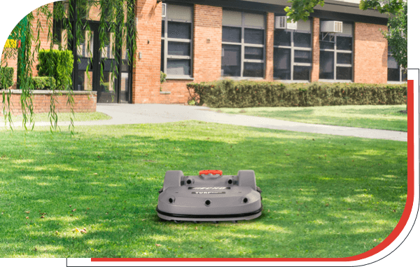 ECHO Robotics’ robotic turf mower near school building.